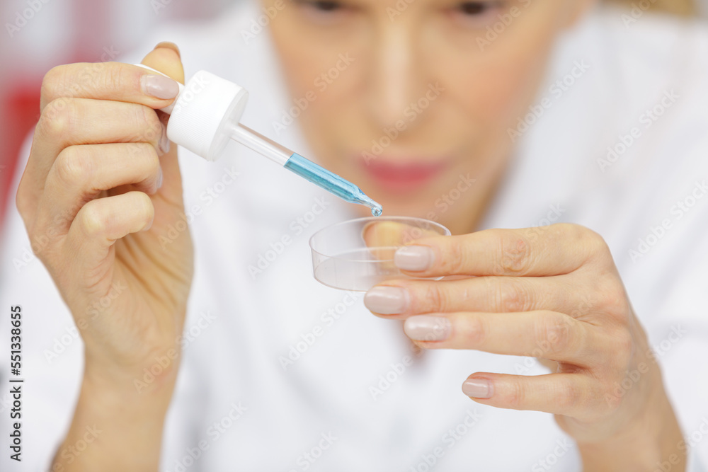 senior woman working with pipettes in a lab senior woman working with pipettes in a lab