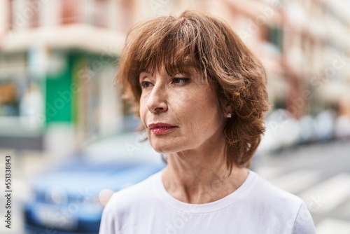 Middle age woman looking to the side with serious expression at street