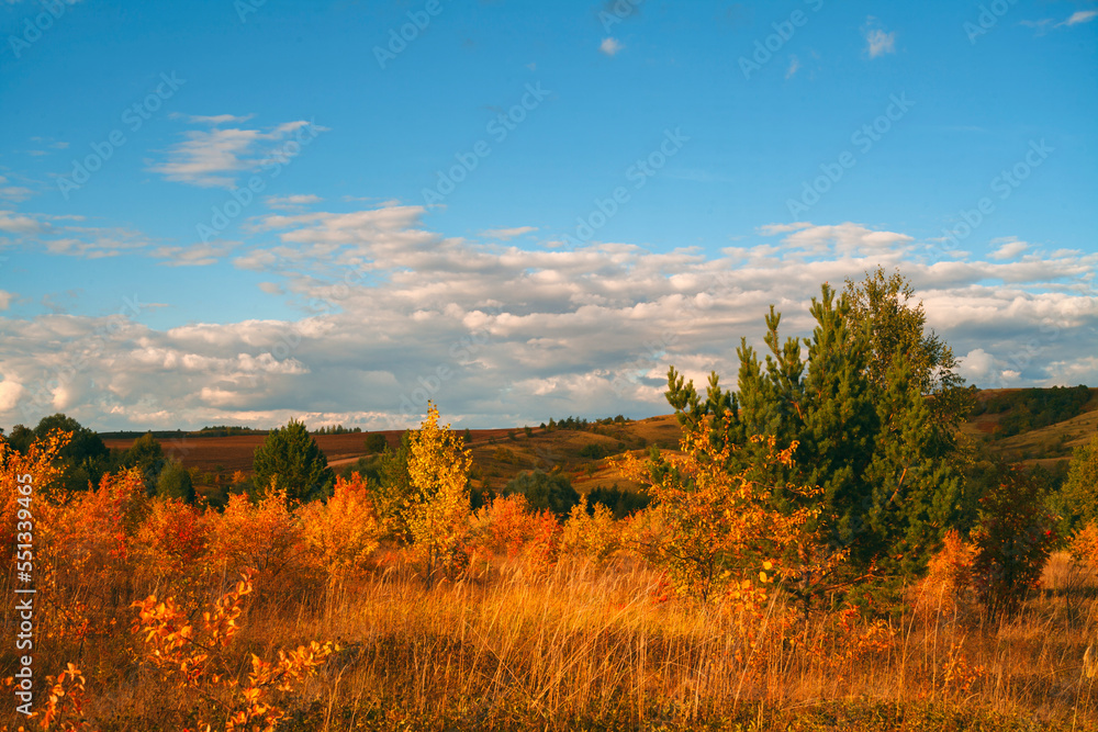 Beautiful mountain landscape. Mountains in the rays of the setting sun, in autumn.Green forest. Blue sky with beautiful clouds. park. Russia.	