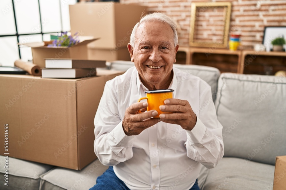Senior man smiling confident drinking coffee at new home Senior man smiling confident drinking coffee at new home