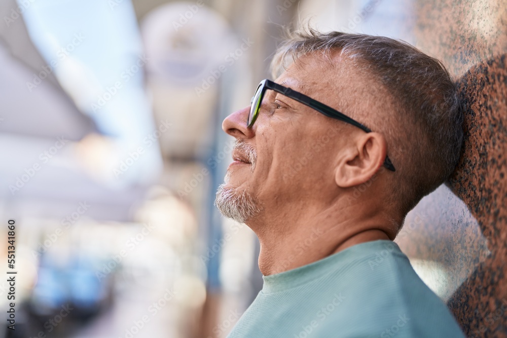 Middle age grey-haired man smiling confident looking to the side at street Middle age grey-haired man smiling confident looking to the side at street