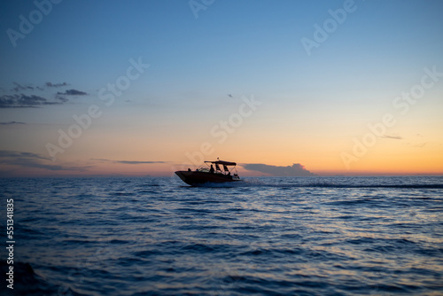 motorboat silhouette racing into the sunset