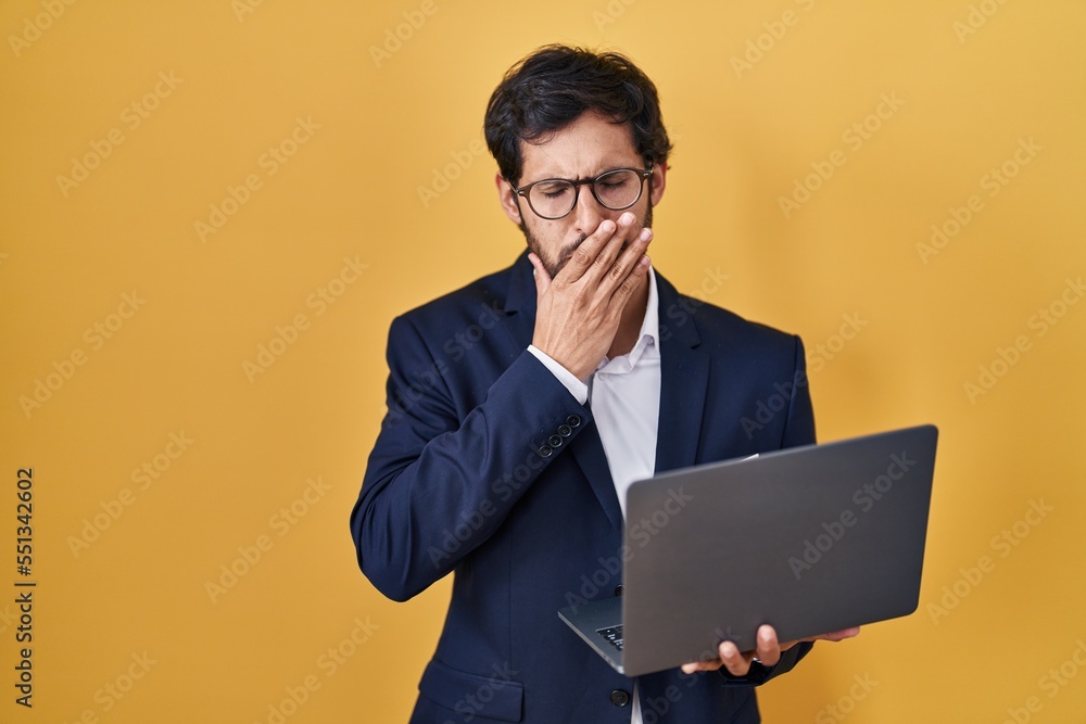 Handsome latin man working using computer laptop bored yawning tired covering mouth with hand. restless and sleepiness. Handsome latin man working using computer laptop bored yawning tired covering mouth with hand. restless and sleepiness.