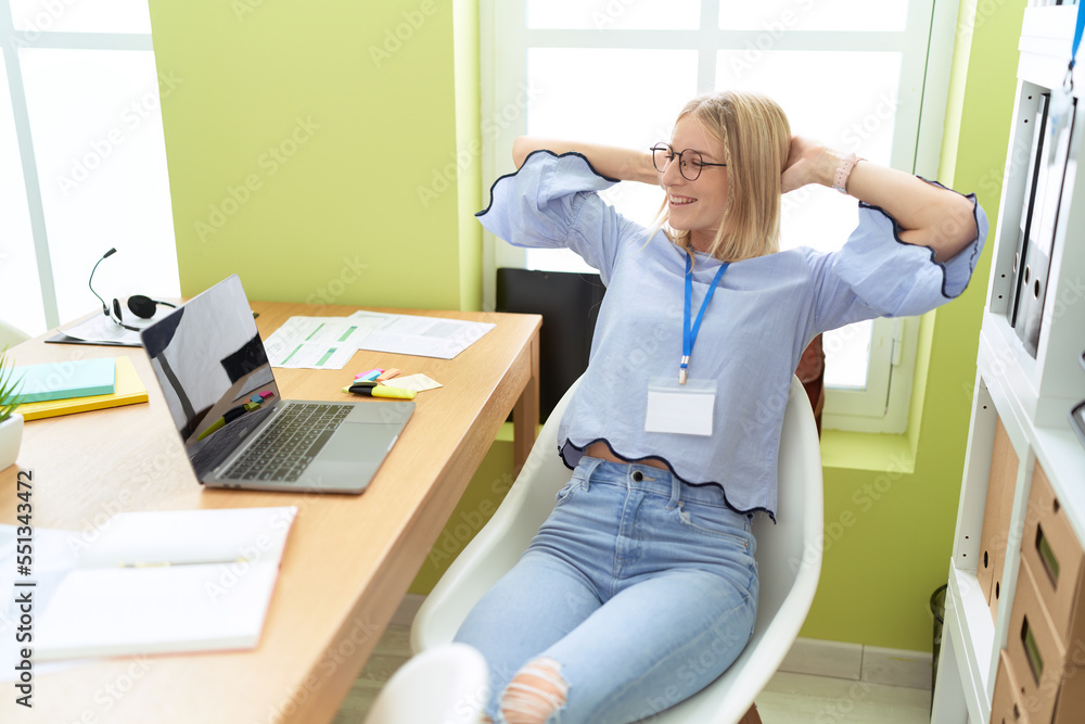 Young blonde woman business worker relaxed with hands on head at office