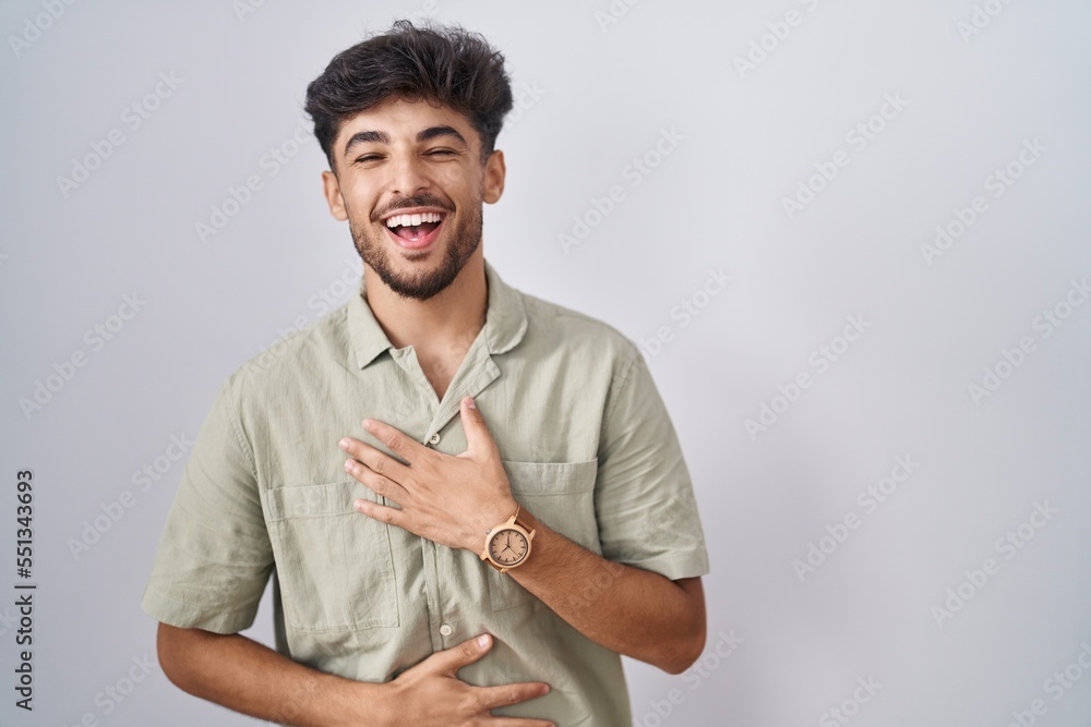 Arab man with beard standing over white background smiling and laughing hard out loud because funny crazy joke with hands on body. Arab man with beard standing over white background smiling and laughing hard out loud because funny crazy joke with hands on body.