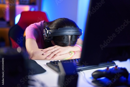 Young chinese woman streamer stressed using computer at gaming room