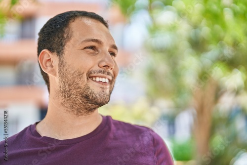 Young man smiling confident looking to the side at park