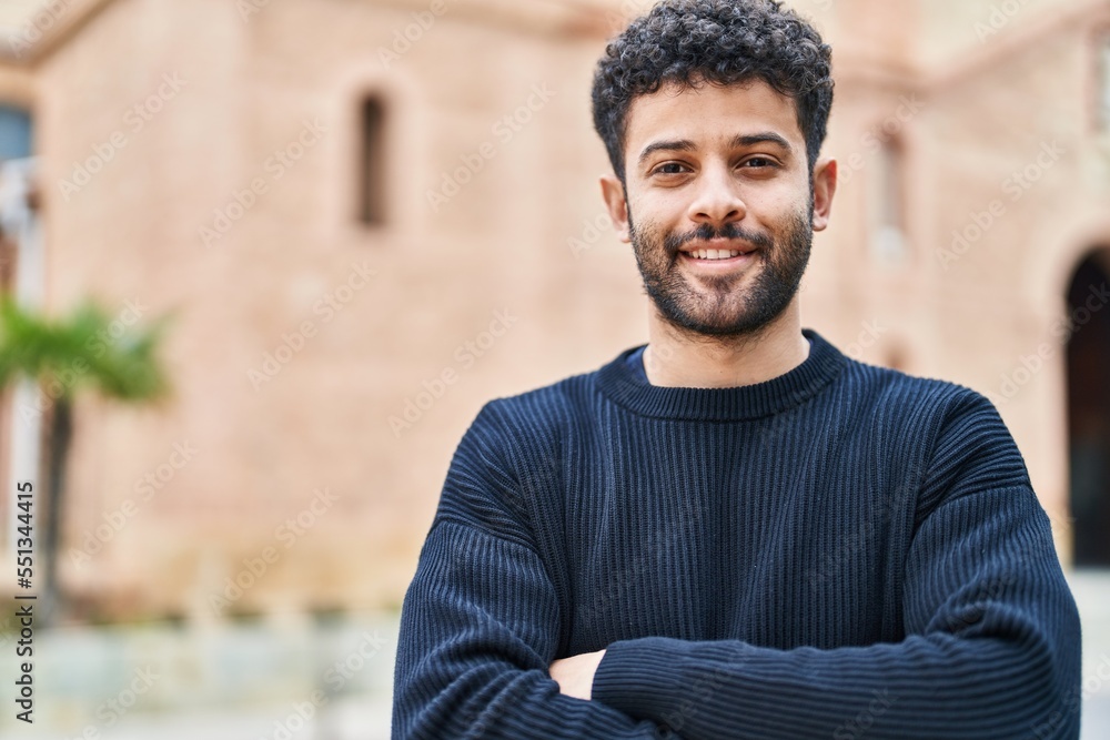 Obraz premium Young arab man smiling confident standing with arms crossed gesture at street