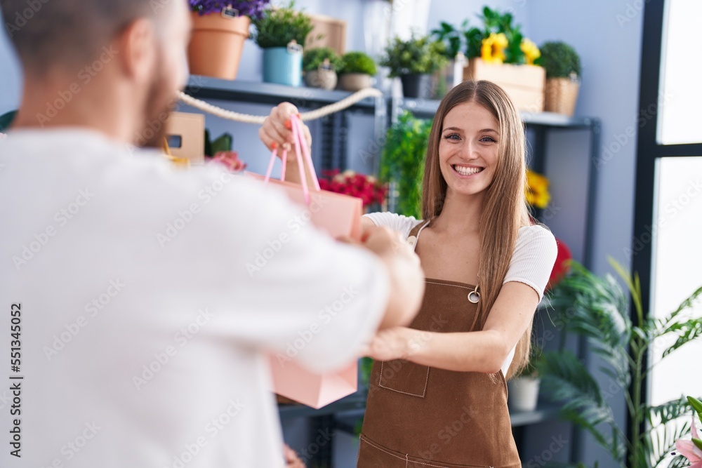 Man and woman customer holding shopping bag at flower shop Man and woman customer holding shopping bag at flower shop
