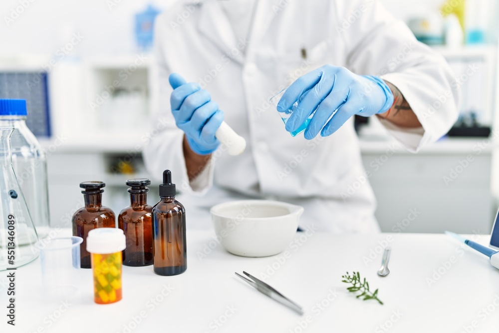 Handsome hispanic man using scientific mortar at laboratory Handsome hispanic man using scientific mortar at laboratory