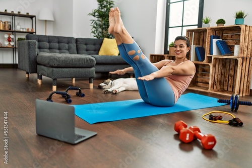 Young woman smiling confident having online abs exercise class at home