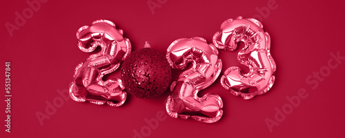 Banner of Viva Magenta color of 2023. Foil gold air balloons in the form of numbers 2023 with shiny Christmas bauble. New year and christmas celebration. Happy new year and festive concept.