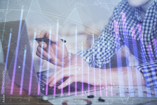 Double exposure of forex graph with man working on computer on background. Concept of market analysis.