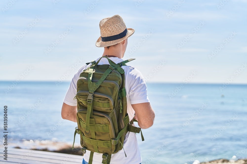 Naklejka premium Young caucasian man tourist standing on back view at street