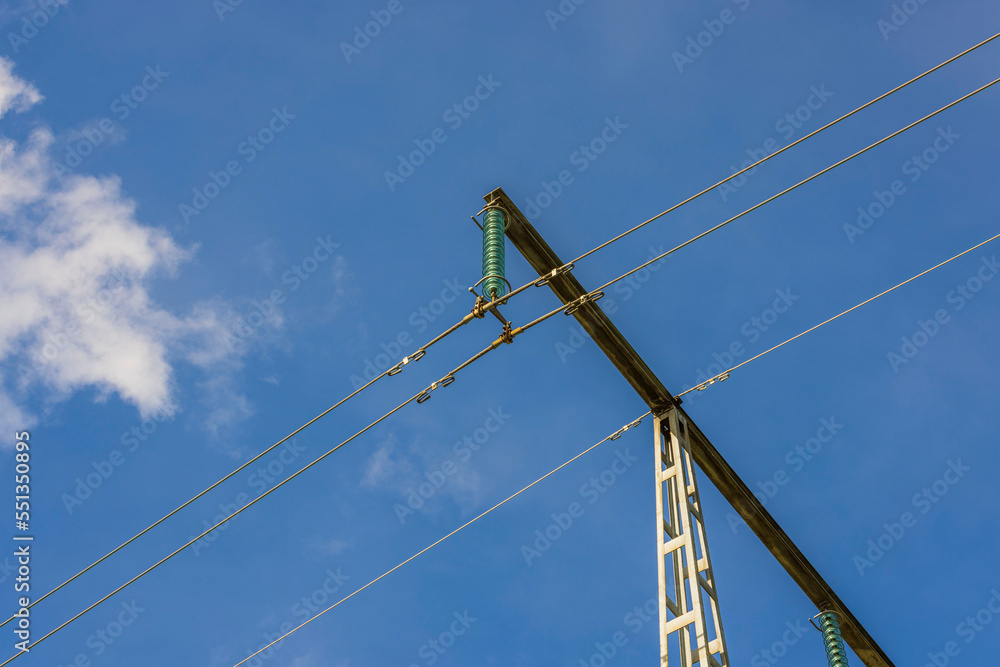 View of high-voltage electric power transmission line on blue sky background. Sweden. 