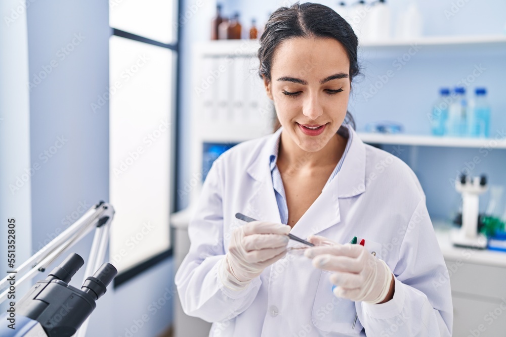 Young hispanic woman wearing scientist uniform working at laboratory Young hispanic woman wearing scientist uniform working at laboratory