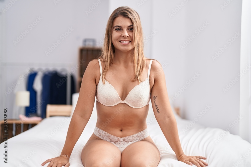 Young woman wearing lingerie sitting on bed at bedroom Young woman wearing lingerie sitting on bed at bedroom