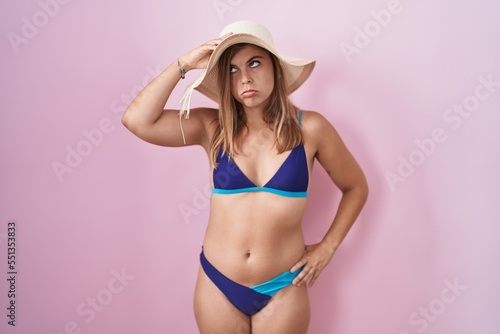 Young hispanic woman wearing bikini over pink background worried and stressed about a problem with hand on forehead, nervous and anxious for crisis