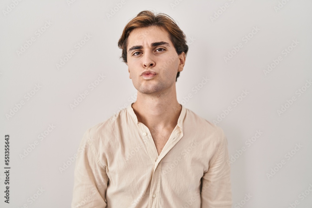 Young man standing over isolated background looking at the camera blowing a kiss on air being lovely and sexy. love expression. Young man standing over isolated background looking at the camera blowing a kiss on air being lovely and sexy. love expression.
