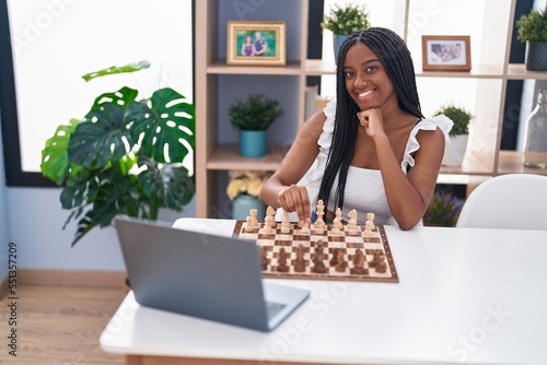 African american woman playing online chess game at home