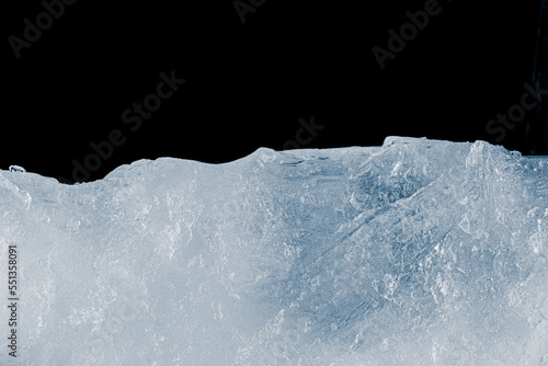 Ice texture background. The textured crunchy ice surface on black background.