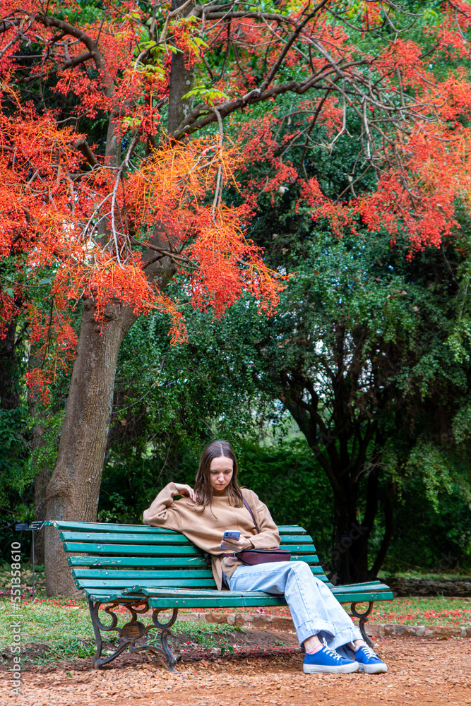 a young girl in the park sitting under a tree a young girl in the park sitting under a tree