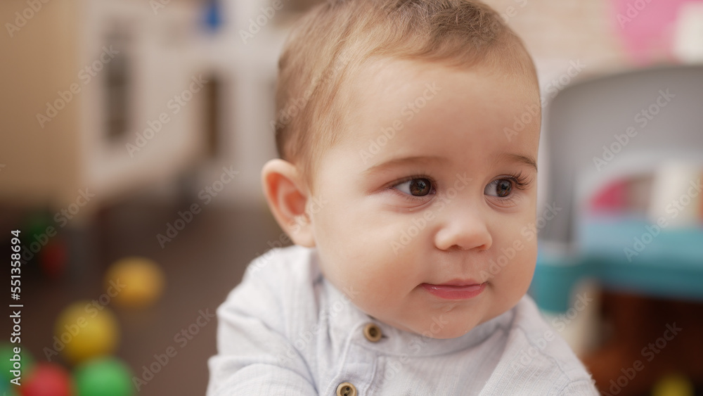 Adorable toddler standing with serious expression at kindergarten Adorable toddler standing with serious expression at kindergarten