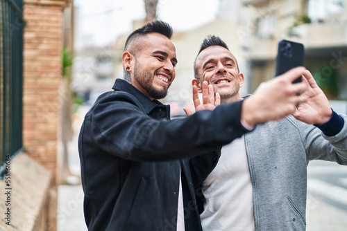 Two men couple smiling confident having video call at street
