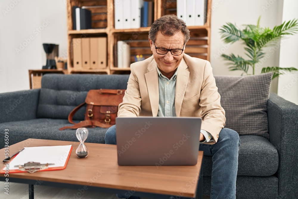 Middle age man having psychology session using laptop at clinic