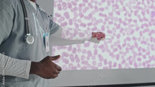 Medium section shot of unrecognizable African American medical worker making presentation at conference or giving lecture to students