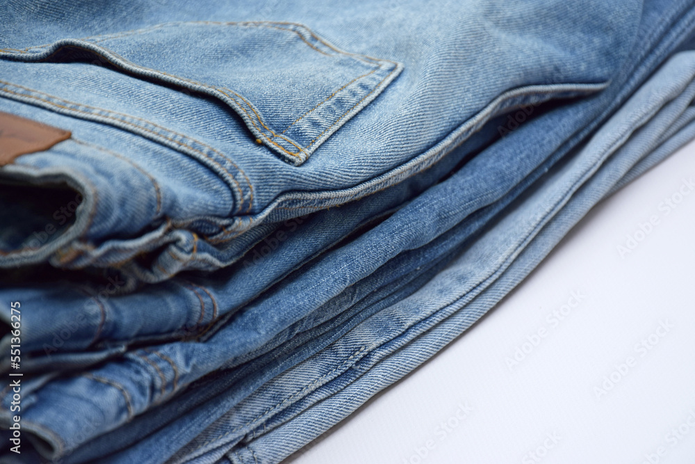 Lots of jeans pants in a stack. Denim background. Lots of jeans pants in a stack. Denim background.