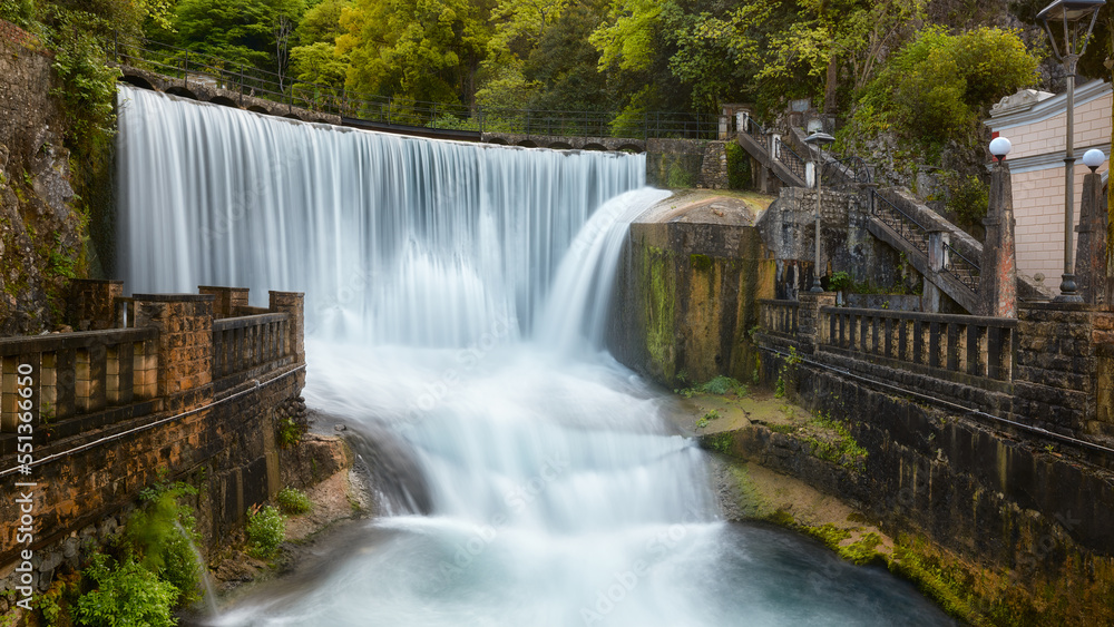 The most beautiful waterfall in New Athos surrounded by ancient walls. Waterfall with blurred water movement. The most beautiful waterfall in New Athos surrounded by ancient walls. Waterfall with blurred water movement.