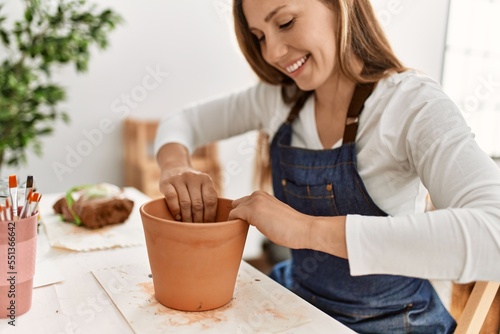 Young caucasian woman smiling confident make handmade clay pot at art studio