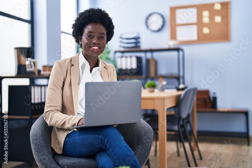 Young african american woman business worker using laptop sitting on chair at office