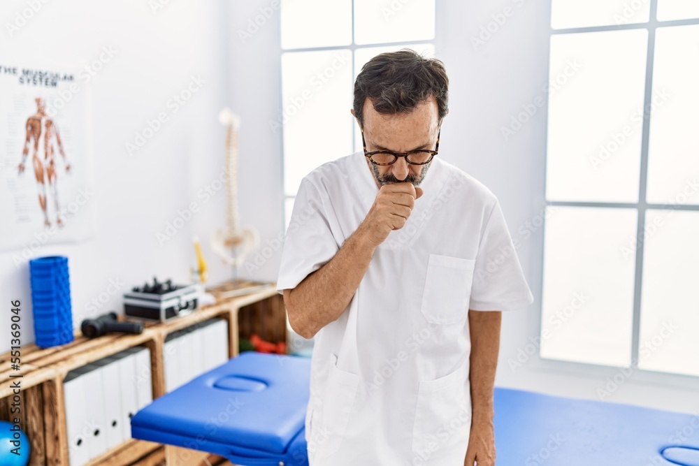 Middle age man with beard working at pain recovery clinic feeling unwell and coughing as symptom for cold or bronchitis. health care concept. Middle age man with beard working at pain recovery clinic feeling unwell and coughing as symptom for cold or bronchitis. health care concept.