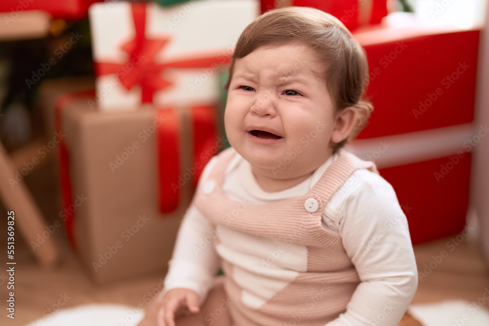 Adorable toddler sitting on floor by christmas gift crying at home Adorable toddler sitting on floor by christmas gift crying at home