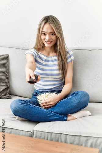 Young chinese woman smiling confident watching movie at home