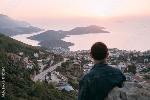 A young man meets on a mountain by the sea meets the sunset.