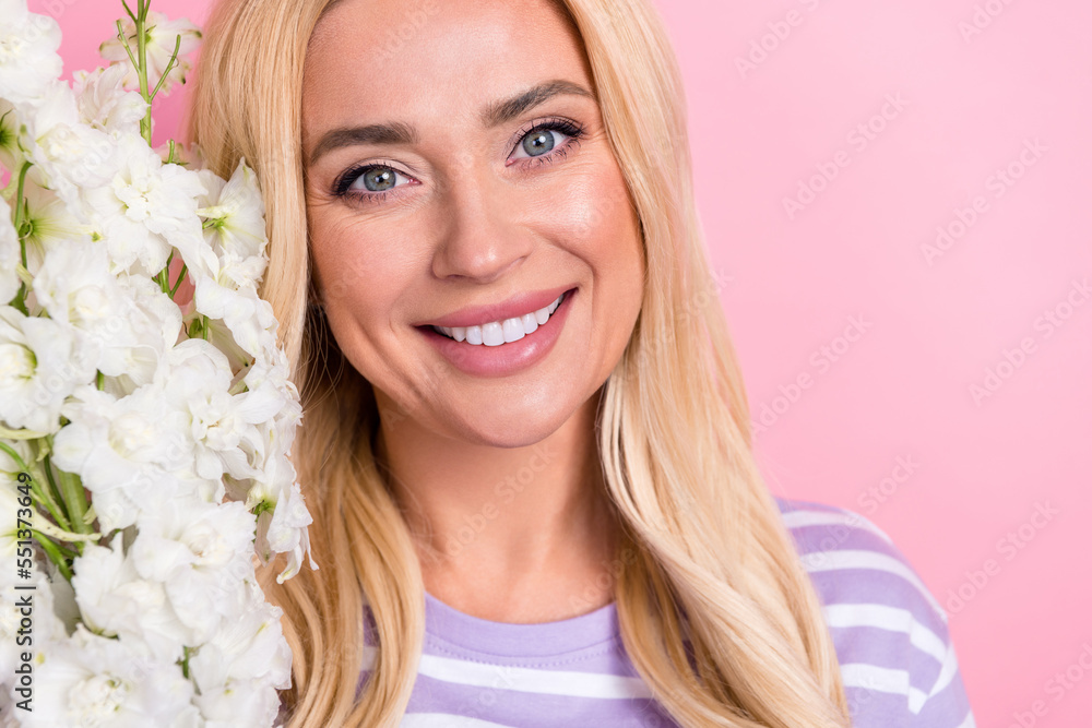 Cropped close up photo of lovely pretty person beaming smile white flowers branch isolated on pink color background Cropped close up photo of lovely pretty person beaming smile white flowers branch isolated on pink color background