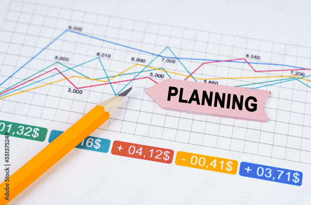 On business charts there is a pencil and an arrow sticker with the inscription - PLANNING On business charts there is a pencil and an arrow sticker with the inscription - PLANNING