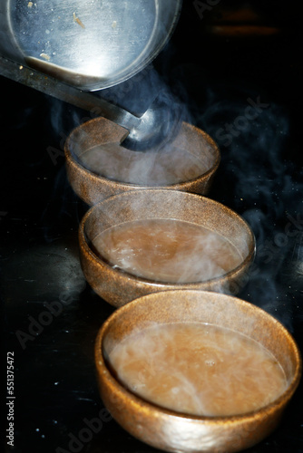 traditional brown onion soups pouring into a bowl