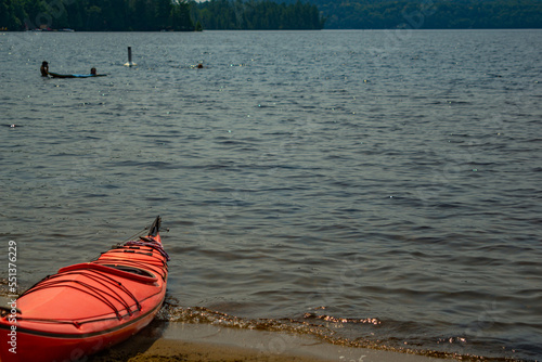 Red canoe on the shore of lake Dwight, Muskoka, Ontario, Canada photo
