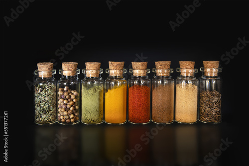 Close-up of coloured spices in glass bottles