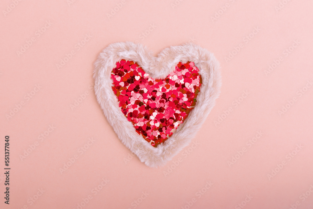 Fluffy fur heart with sparkles in the form of hearts on a red background. The concept of Valentine's day, love, dating and wedding. Copy space.