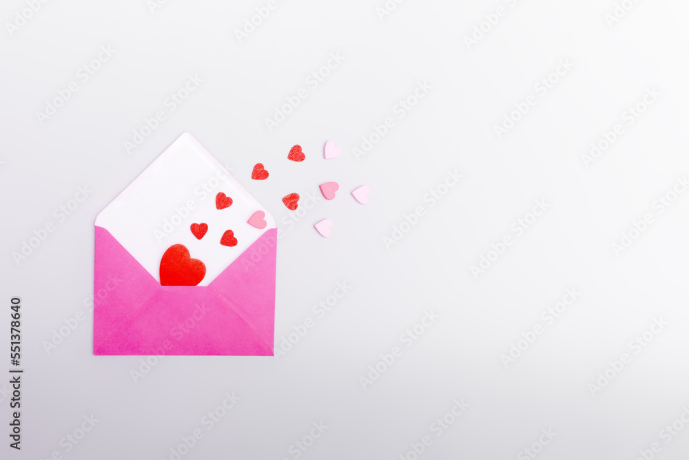 Pink envelope and hearts on a gray background. The concept of Valentine's day, love, dating and wedding. Symbol of love letters. Copy space, flat lay. Pink envelope and hearts on a gray background. The concept of Valentine's day, love, dating and wedding. Symbol of love letters. Copy space, flat lay.