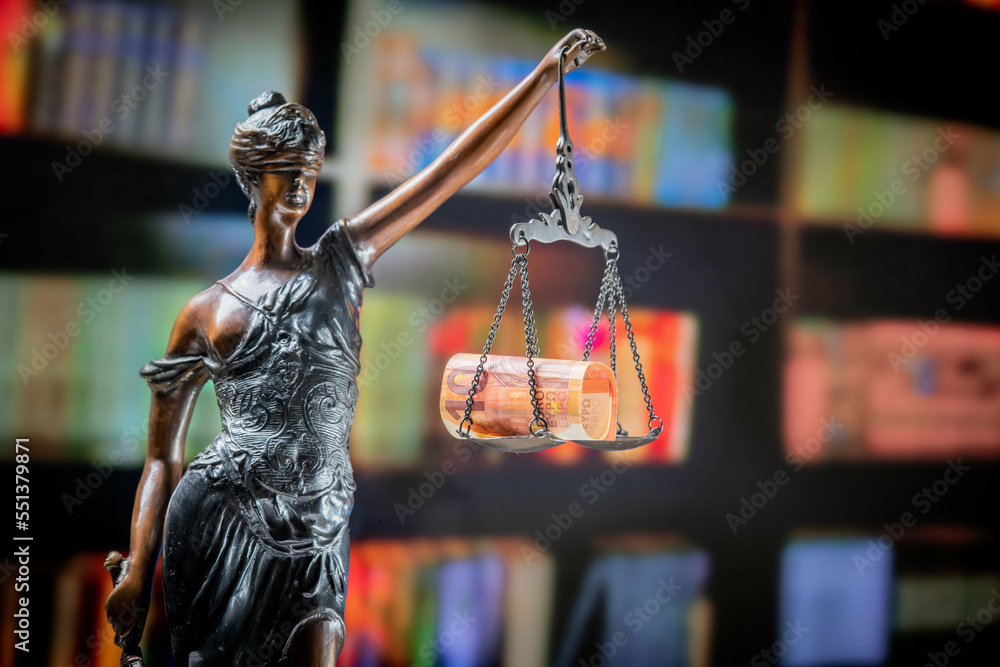 Goddess of justice statue in lawyer cabinet on bookshelf background