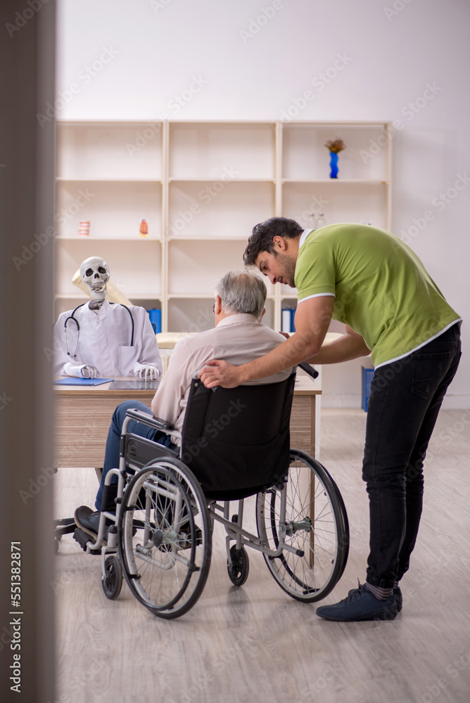 Old patient in wheel-chair visiting skeleton doctor