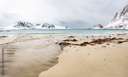 scenic landscape with beach, ocean and mountains near Nusfjord town at the Lofoten Islands in Norway