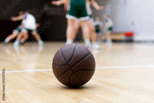 A basketball on the wooden floor as background. Team sport concept