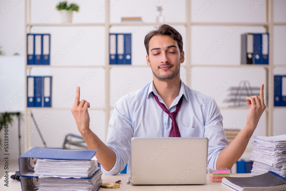 Young male employee and too much work in the office Young male employee and too much work in the office